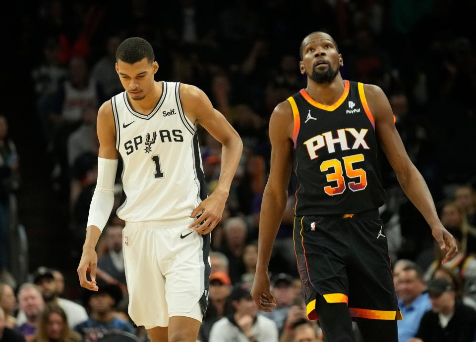 San Antonio Spurs center Victor Wembanyama (1) and Phoenix Suns forward Kevin Durant (35) walk up court during the first quarter at Footprint Center in Phoenix on Oct. 31, 2023.