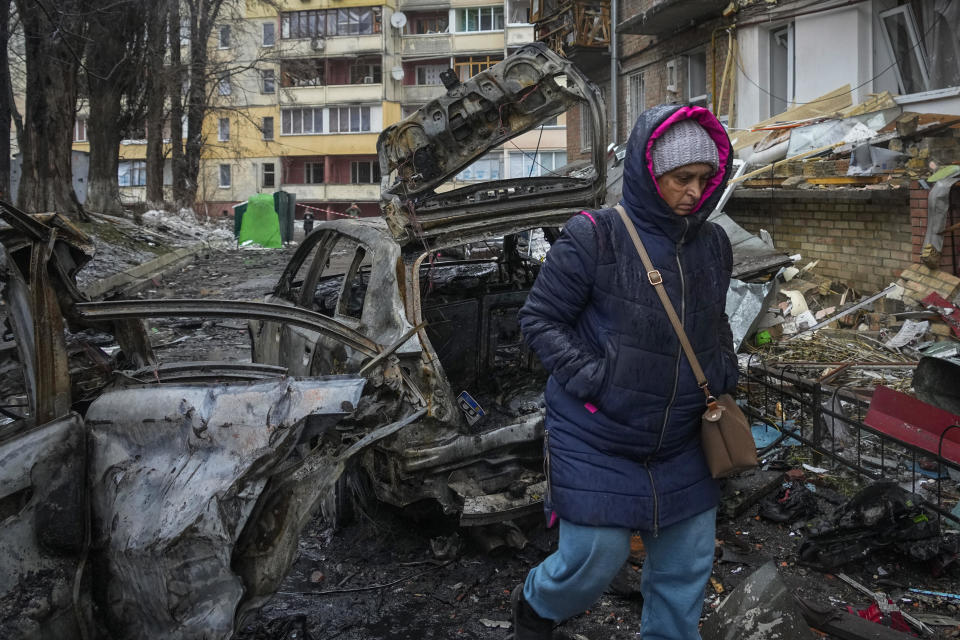 A woman walks by homes damaged during Russian shelling in the town of Vyshgorod, outside Ukraine's capital of Kyiv, November 24, 2022. About 70% of the Ukrainian capital was left without power after Moscow unleashed another devastating missile barrage on the country's energy infrastructure, Kyiv's mayor said. / Credit: Efrem Lukatsky/AP