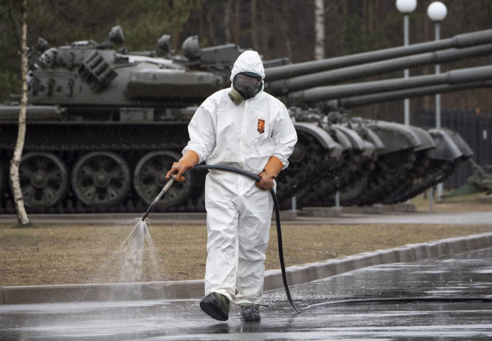 A specialist from a local veterinary service wears a protective suit as sprays disinfectant near Russian tanks displayed at area near Proryv (The Breakthrough) museum dedicated to the breakthrough of the Siege of Leningrad during World WarII near Kirovsk, about 30 kilometres (19 miles) east of St.Petersburg, Russia, Thursday, April 2, 2020. The new coronavirus causes mild or moderate symptoms for most people, but for some, especially older adults and people with existing health problems, it can cause more severe illness or death. (AP Photo/Dmitri Lovetsky)