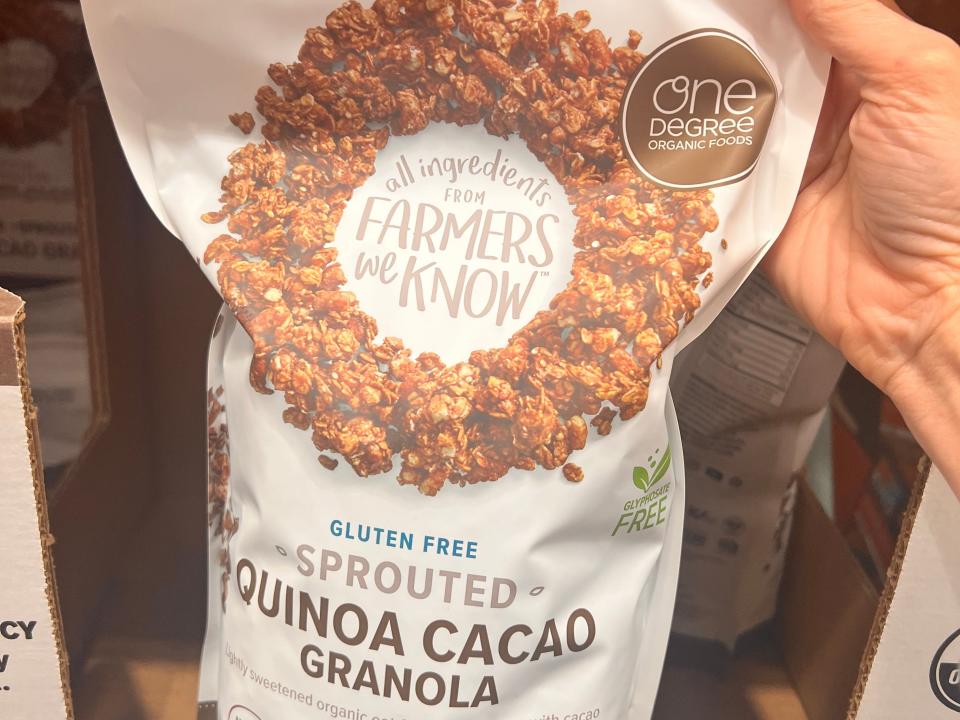 hand holding up a big bag of quinoa cacao granola at costco
