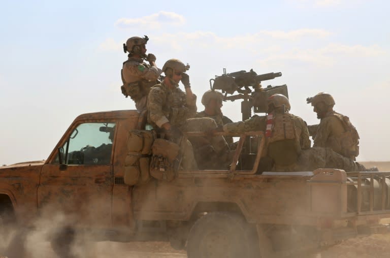 Armed men in uniform identified by Syrian Democratic Forces as US special operations personnel ride in a pickup truck in the village of Fatisah in the northern Syrian province of Raqa on May 25, 2016