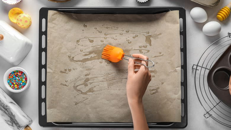 Brushing oil on parchment paper on a pan