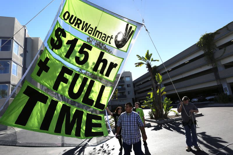 FILE PHOTO: People hold up a sign during a Black Friday protest against Walmart in Long Beach