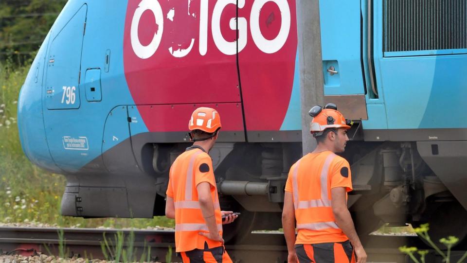 PHOTO: SNCF employees look on as a TGV train moves past them at Vald'yerre on the outskirts of Chartres, northern France, on July 26, 2024. (Jean-francois Monier/AFP via Getty Images)