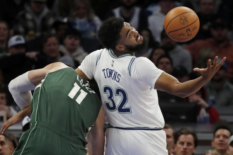 Minnesota Timberwolves forward Karl-Anthony Towns (32) tries to keep control of the ball as Milwaukee Bucks center Brook Lopez (11) defends during the first quarter of an NBA basketball game Friday, Feb. 23, 2024, in Minneapolis. (AP Photo/Bruce Kluckhohn)