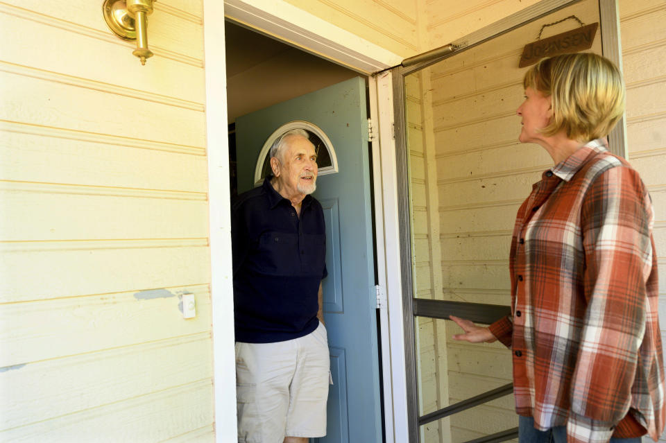 Carl Johnsen speaks with neighbor Heidi Lange at his Paradise, Calif., home, Thursday, Oct. 26, 2023. Facing a $14,702 quote to renew his homeowners insurance, Johnsen plans to let coverage lapse when it expires in November. (AP Photo/Noah Berger)