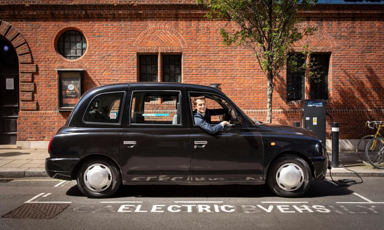 <span>Plugged in: Jasper Jolly behind the wheel of a retrofitted black London cab.</span><span>Photograph: Alicia Canter/The Guardian</span>