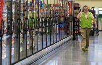 FILE PHOTO: A Wal-Mart employee is reflected in the cold cases at the Wal-Mart Neighborhood Market in Bentonville