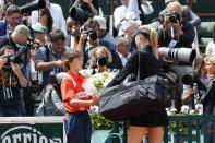 Russia's Maria Sharapova is offered flowers as she arrives on the court prior to play against Italy's Sara Errani their Women's Singles final tennis match of the French Open tennis tournament at the Roland Garros stadium, on June 9, 2012 in Paris. AFP PHOTO / JACQUES DEMARTHONJACQUES DEMARTHON/AFP/GettyImages