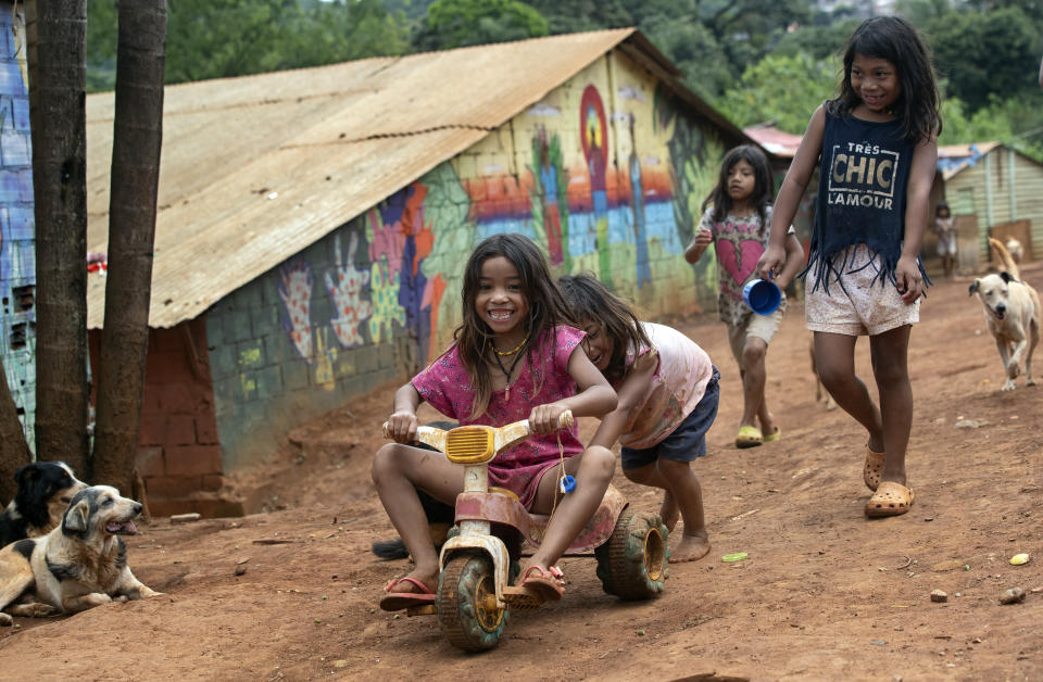 Guarani Mbya children play in their indigenous community in Sao Paulo, Brazil, Friday, Jan. 31, 2020. Members of the tribe, living in the smallest demarcated indigenous land of Brazil, were surprised by workers with chainsaws who were making way for a five-building apartment complex in a nearby forested area. They say they weren’t consulted, as the law states, but the company has permits to build. The tension between a builder with projects in nine Brazilian states and a 40-family indigenous community is a microcosm of what’s playing out elsewhere in the country. (AP Photo/Andre Penner)