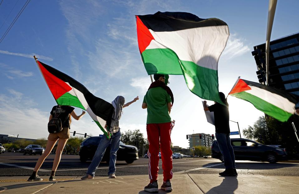 People gather at the crosswalk waiting to cross during a Free Palestine protest at the corner of Scottsdale Road and Greenway-Hayden Loop on March 22, 2024.