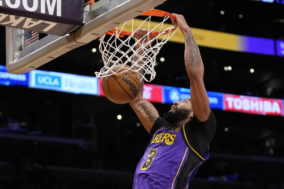 Los Angeles Lakers forward Anthony Davis (3) dunks during the first half of an NBA basketball game against the Denver Nuggets in Los Angeles, Friday, Dec. 16, 2022. (AP Photo/Ashley Landis)