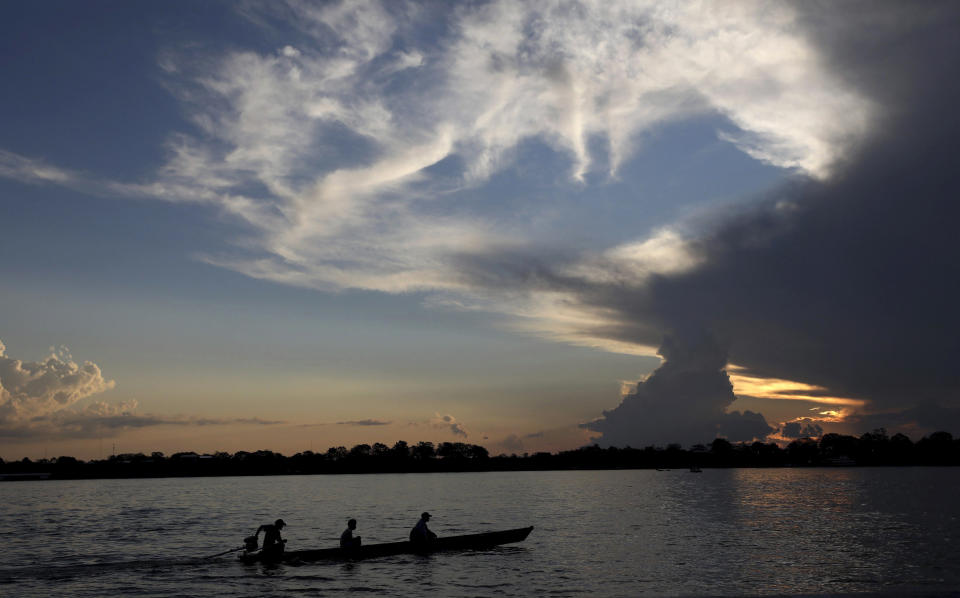 Tres personas se movilizan en una lancha por el río Amazonas cerca de Leticia (Colombia) el 7 de septiembre del 2019. (AP Photo/Fernando Vergara, File)