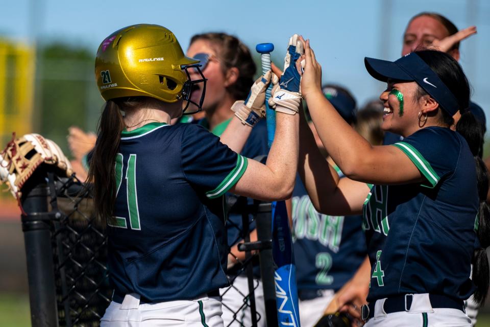 Indianapolis Cathedral High School junior Mary Hughes (21), left, celebrates after scoring during a IHSAA Class 4A Softball Sectional Championship game against Lawrence North High School, Friday, May 26, 2023, at North Central High School.