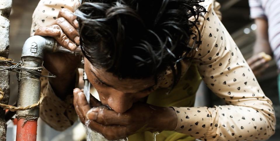 A worker drinks water straight from the tap