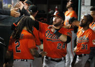 Baltimore Orioles' DJ Stewart is greeted in the dugout by teammates after scoring on an RBI single by Trey Mancini against the Texas Rangers during the eighth inning of a baseball game in Arlington, Texas, Saturday, April 17, 2021. (AP Photo/Ray Carlin)