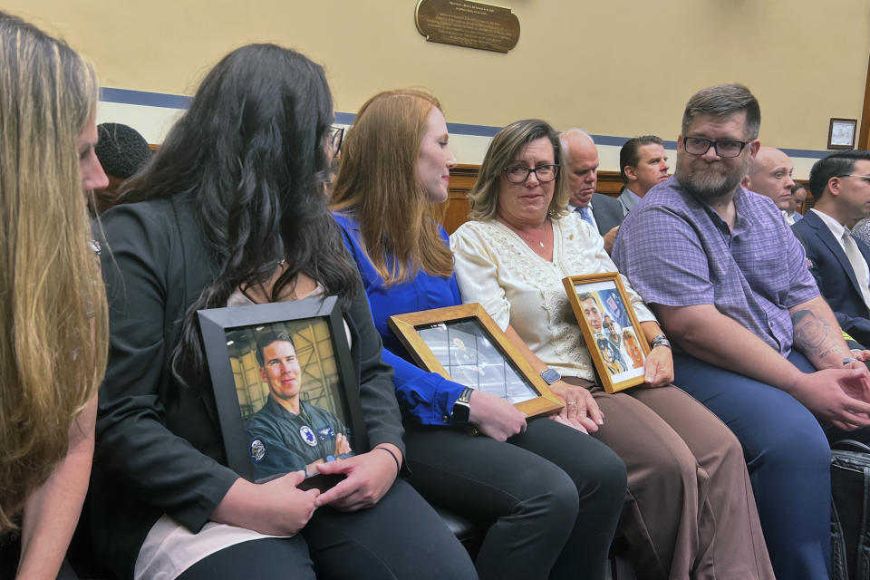 From left, Lisa Hancock and Emily Hancock, mother and sister, respectively, to Capt. Kelsie Hancock, hold a photo of Kelsie's late fiance, Capt. Nicholas Losapio. Amber Sax, holds a photo of her late husband, Capt. John Sax, Michelle Strickland, holds a photo collage of her son, Lance Cpl. Evan Strickland and Evan's father Brett Strickland, talk before a hearing on the safety of the V-22 Osprey program, Wednesday June 12, 2024 on Capitol Hill in Washington. Each of the service members was killed in an Osprey crash. (AP Photo/Tara Copp)