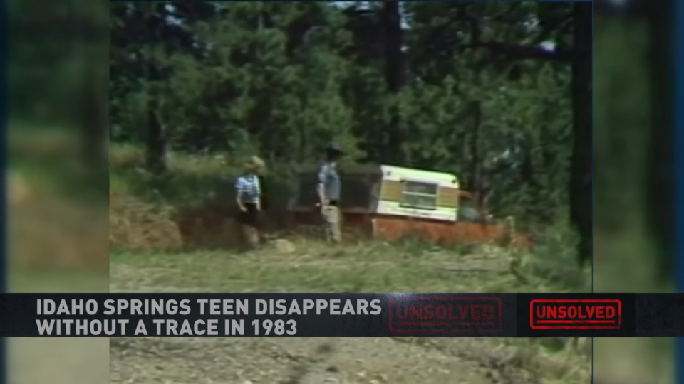 Investigators looking at a red pickup truck