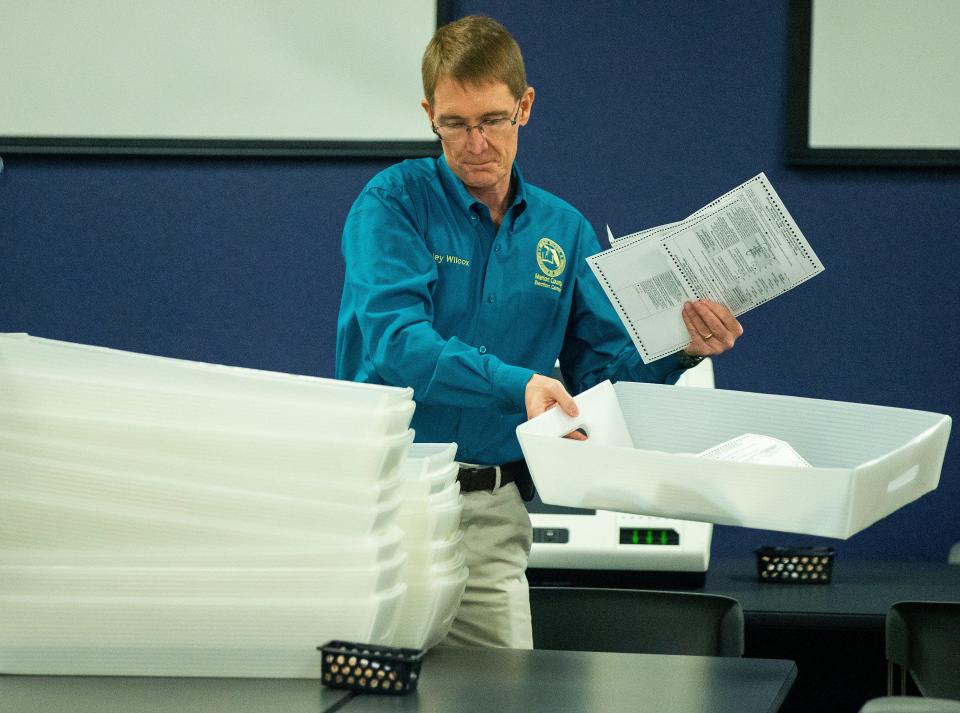 Wesley Wilcox, Marion County Supervisor of Elections, separates trays containing ballots for different precincts to be counted November 2, 2020.