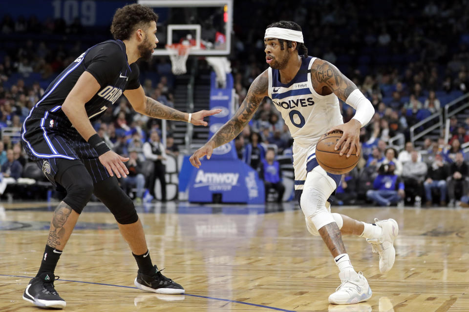 Minnesota Timberwolves guard D'Angelo Russell (0) looks to get around Orlando Magic guard Michael Carter-Williams during the first half of an NBA basketball game Friday, Feb. 28, 2020, in Orlando, Fla. (AP Photo/John Raoux)