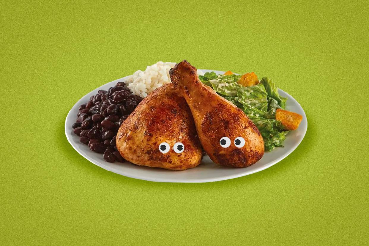 A chicken dinner on a white plate has googly eyes. 