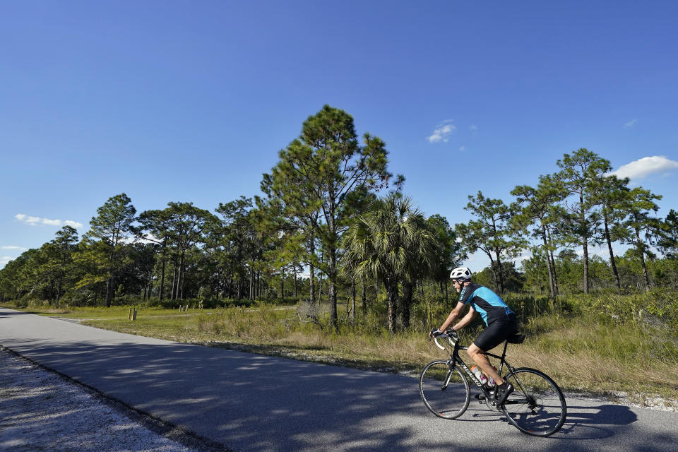 A man bikes through the Flatwood Conservation Park on Friday, Oct. 22, 2021, outside Tampa, Fla. The census lists no people living in the Flatwoods Conservation Park outside Tampa, even though it says there is a home occupied by people. According to Hillsborough County spokesman Todd Pratt, two county employees live there while maintaining security for the park. (AP Photo/Chris O'Meara)