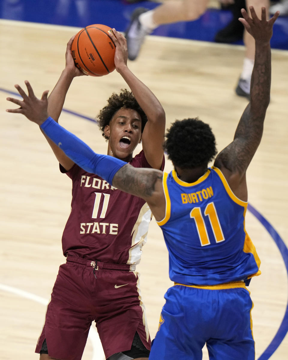 Florida State forward Baba Miller (11) looks for an outlet as Pittsburgh guard Jamarius Burton (11) defends during the second half of an NCAA college basketball game in Pittsburgh, Saturday, Jan. 21, 2023. Florida State won 71-64. (AP Photo/Gene J. Puskar)
