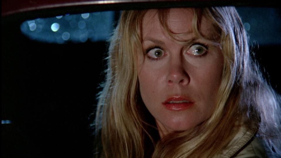 Elizabeth Montgomery in the front seat of a car, her hair wet from the rain outside, looks terrified in the horror tv movie, The Victim.