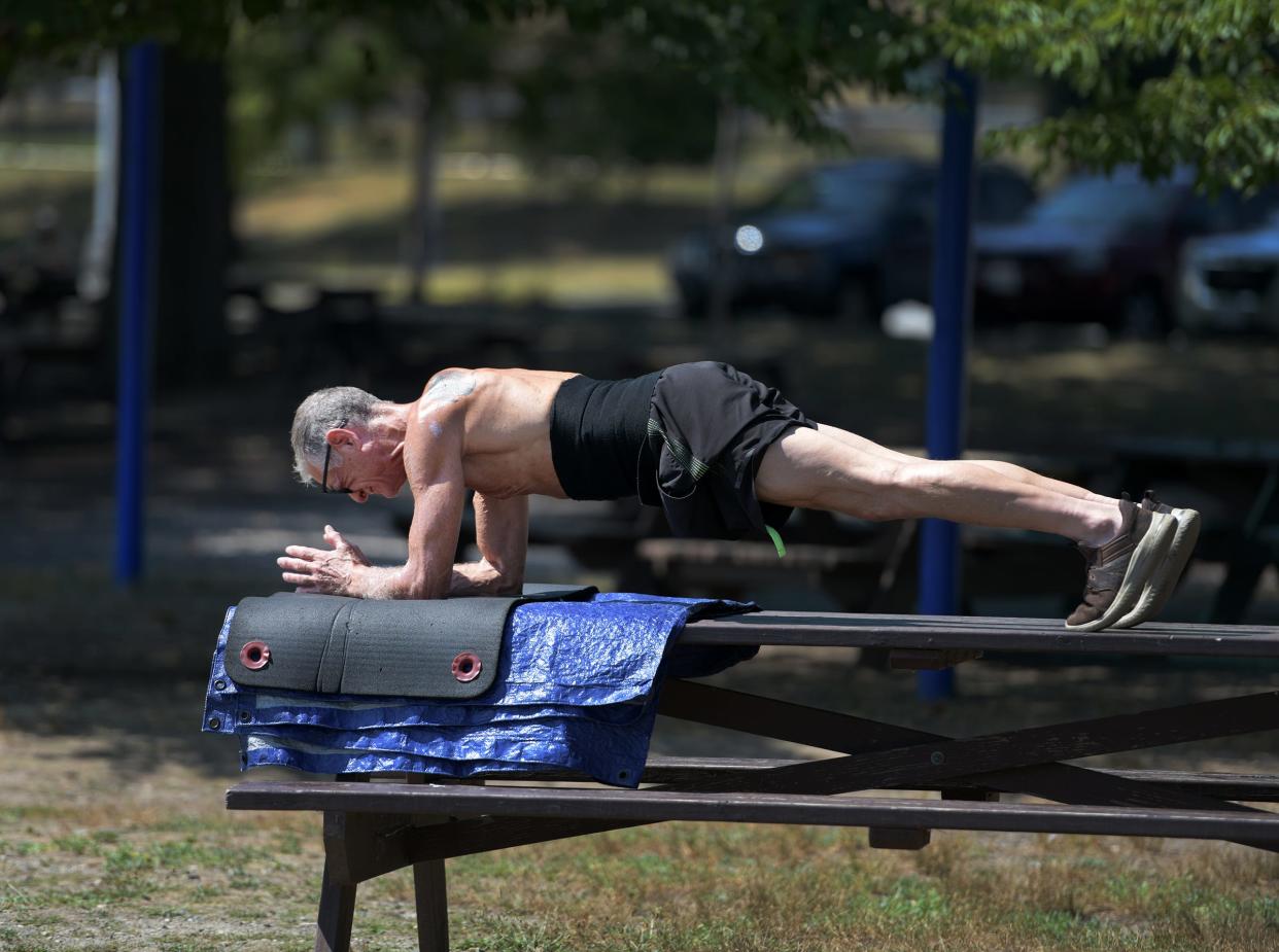 David Bratko 64, works out at Regatta Point by doing planks, unfazed by Monday's heat. He does a variety of exercises for about five hours per day.