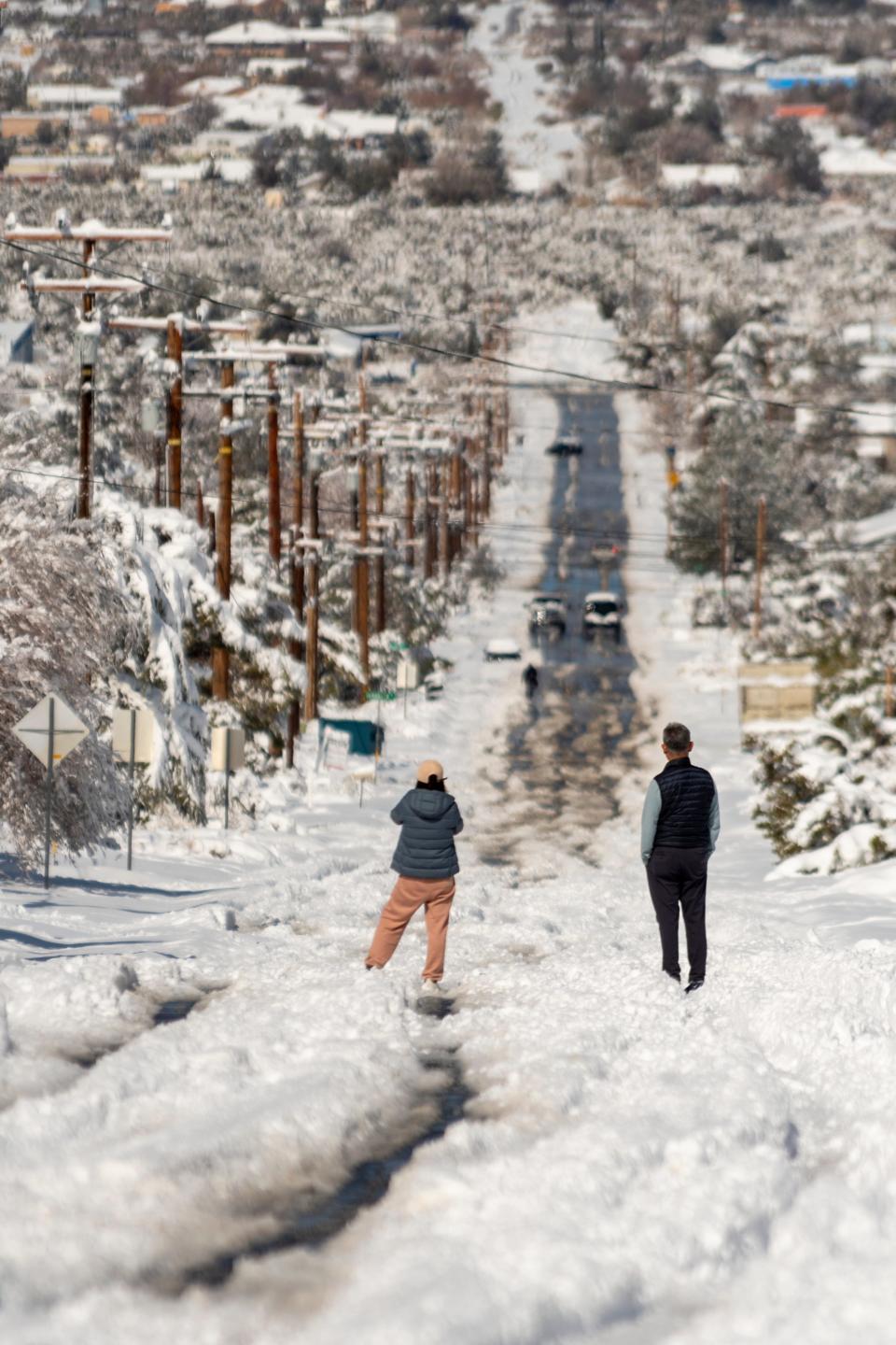 Pinon Hills residents watch snow melt off a road on Saturday February 25, 2023. Some parts of Phelan and Pinon Hills received more than a foot of snow in Saturday’s storm. (James Quigg, for the Daily Press)