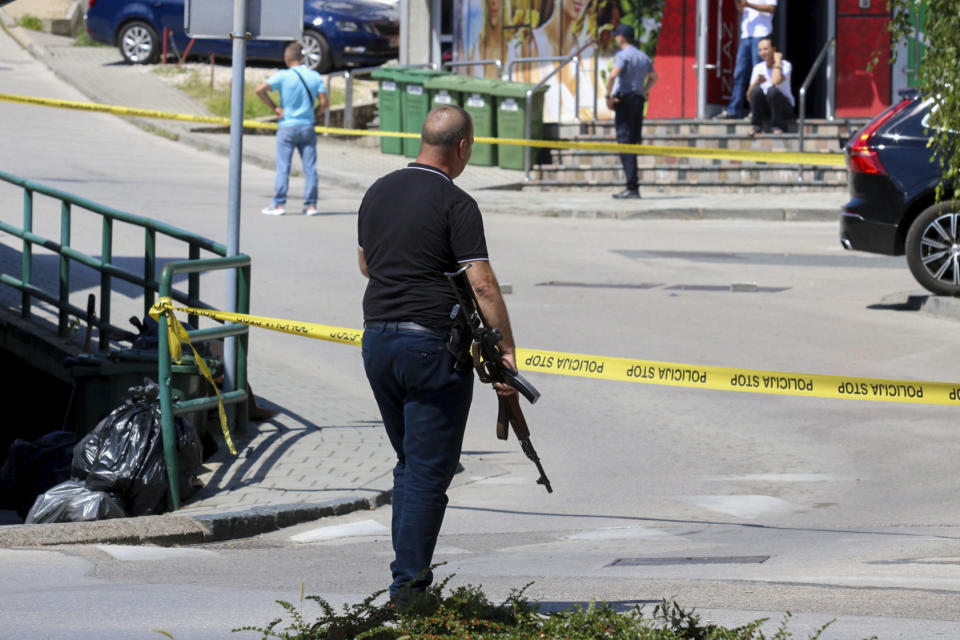 A plain-clothes police officer holds a rifle as they launch a major chase for a man who claimed to have shot and killed his wife while broadcasting it live on Instagram, in the small town of Gradacac, Bosnia, Friday, Aug. 11, 2023. (AP Photo)