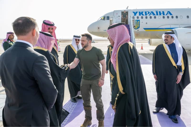 Ukrainian President Volodymyr Zelensky welcomed by officials upon his arrival at the airport. -/Saudi Press Agency/dpa