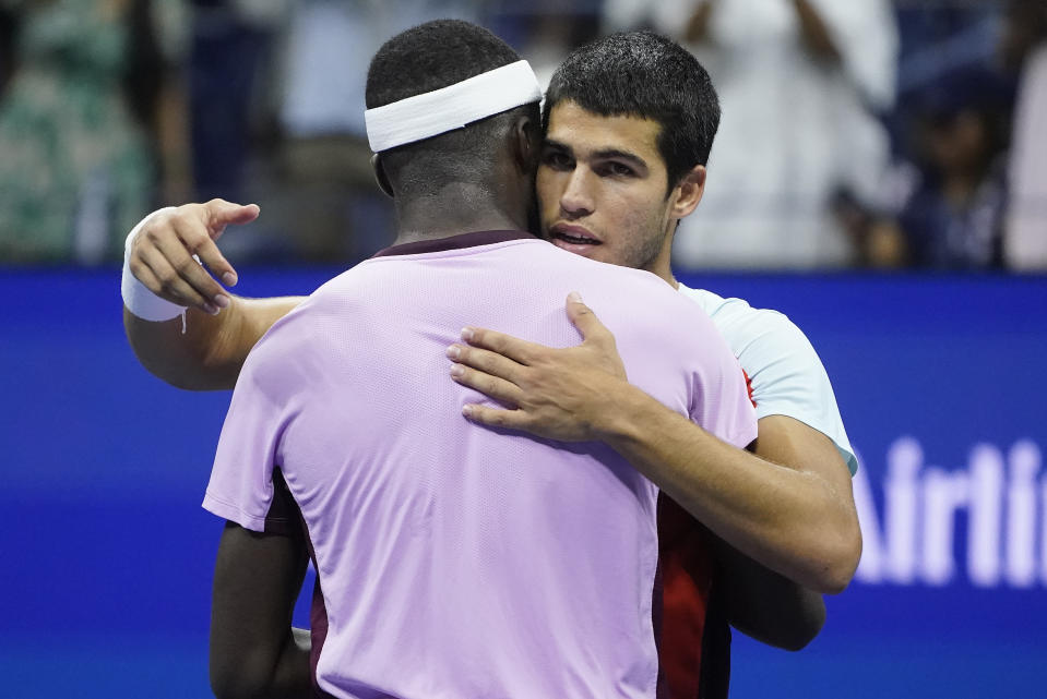 Carlos Alcaraz, of Spain, right, hangs Frances Tiafoe, of the United States, after winning their semifinal match of the U.S. Open tennis championships, Friday, Sept. 9, 2022, in New York. (AP Photo/John Minchillo)