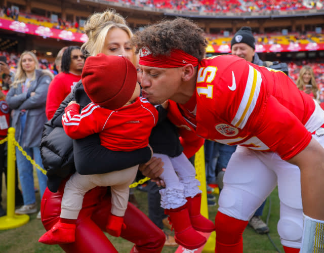 KANSAS CITY, MISSOURI – DECEMBER 10: Patrick Mahomes #15 of the Kansas City Chiefs, kisses his second child, Patrick Bronze Lavon Mahomes III, on the sidelines prior to the game against the Buffalo Bills at GEHA Field at Arrowhead Stadium on December 10, 2023 in Kansas City, Missouri. <em>Photo by David Eulitt/Getty Images.</em>