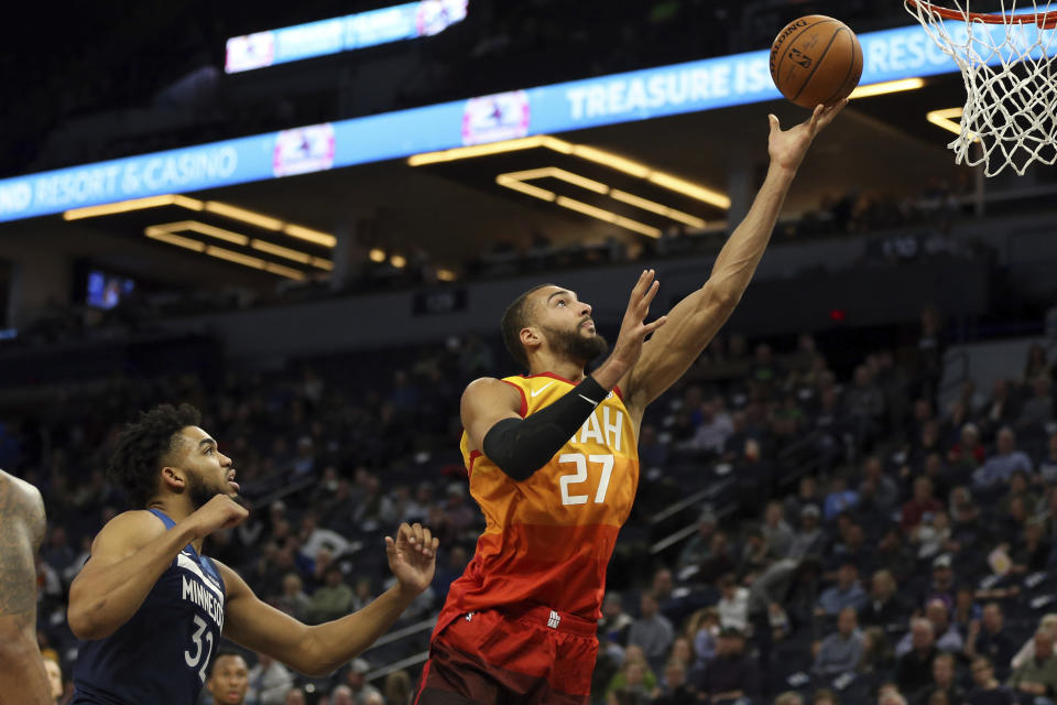 Utah Jazz's Rudy Gobert shoots the ball against Minnesota Timberwolves' Karl-Anthony Towns in the first half of an NBA basketball game Wednesday, Dec. 11, 2019, in Minneapolis. (AP Photo/Stacy Bengs)