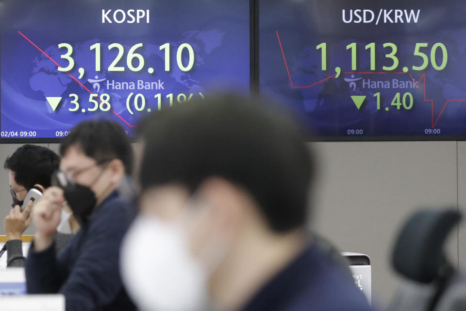 Currency traders watch computer monitors near screens showing the Korea Composite Stock Price Index (KOSPI), left, and the foreign exchange rate between U.S. dollar and South Korean won at the foreign exchange dealing room in Seoul, South Korea, Thursday, Feb. 4, 2021. Asian shares mostly fell Thursday as caution set in over company earnings reports, recent choppy trading in technology stocks and prospects for more economic stimulus for a world battling a pandemic. (AP Photo/Lee Jin-man)