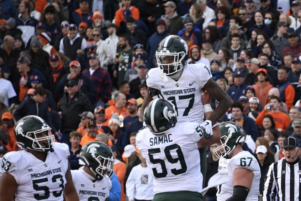 Michigan State wide receiver Tre Mosley (17) celebrates with center Nick Samac (59) after he scored a touchdown against Illinois during the first half of an NCAA college football game, Saturday, Nov. 5, 2022, in Champaign, Ill.