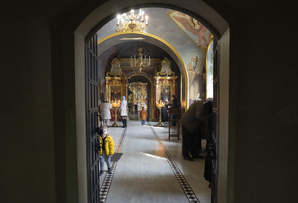 People pray at the entrance to an underground labyrinth with holy relics in the Monastery of the Caves, also known as Kyiv-Pechersk Lavra, one of the holiest sites of Eastern Orthodox Christians, in Kyiv, Ukraine, Thursday, March 23, 2023. Tensions are on the rise at a prominent Orthodox monastery in Kyiv where the monks are facing eviction later this month. The Ukrainian government accuses the monks of links to Moscow, even though they claim to have severed ties with the Russian Orthodox Church following Russia's full-scale of invasion of Ukraine. (AP Photo/Efrem Lukatsky)