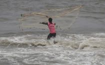 An Indian fisherman cast his net during high tide at Arabian Sea in Mumbai, India, June 19, 2019.(AP Photo/Rafiq Maqbool)