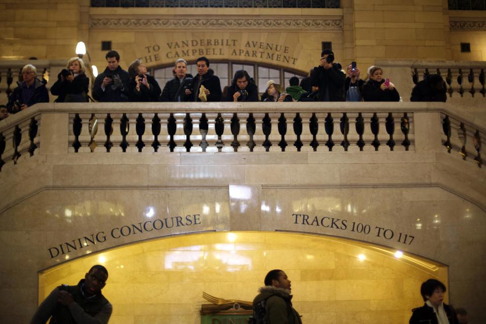 Commuters stand on a staircase to take photographs inside of Grand Central Station in New York, February 1, 2013. Grand Central Terminal, the doyenne of American train stations, is celebrating its 100th birthday. Opened on Feb. 2, 1913 the iconic New York landmark with its Beaux-Arts facade is an architectural gem, and still one of America's greatest transportation hubs. (REUTERS/Lucas Jackson)