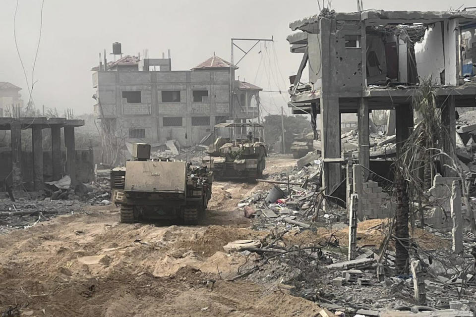 In this undated photo provided by the Israeli military, Israeli armored personnel carriers move past destroyed buildings during a ground operation in the Gaza Strip. Israeli ground forces have been operating in Gaza in recent days as Israel presses ahead with its war against Hamas militants. (Israel Defense Forces via AP)