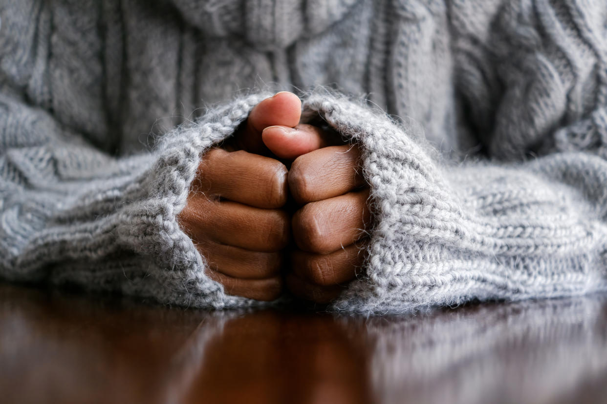 Close-up of unrecognizable black woman with hands on table