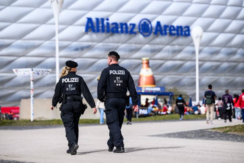 Police officers walk in front of the Allianz Arena ahead of the German Bundesliga soccer match between Bayern Munich and Borussia Dortmund. Tom Weller/dpa