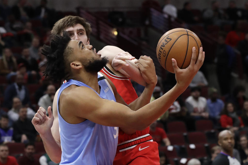 Minnesota Timberwolves center Karl-Anthony Towns, front, shoots against Chicago Bulls forward Luke Kornet during the first half of an NBA basketball game in Chicago, Wednesday, Jan. 22, 2020. (AP Photo/Nam Y. Huh)