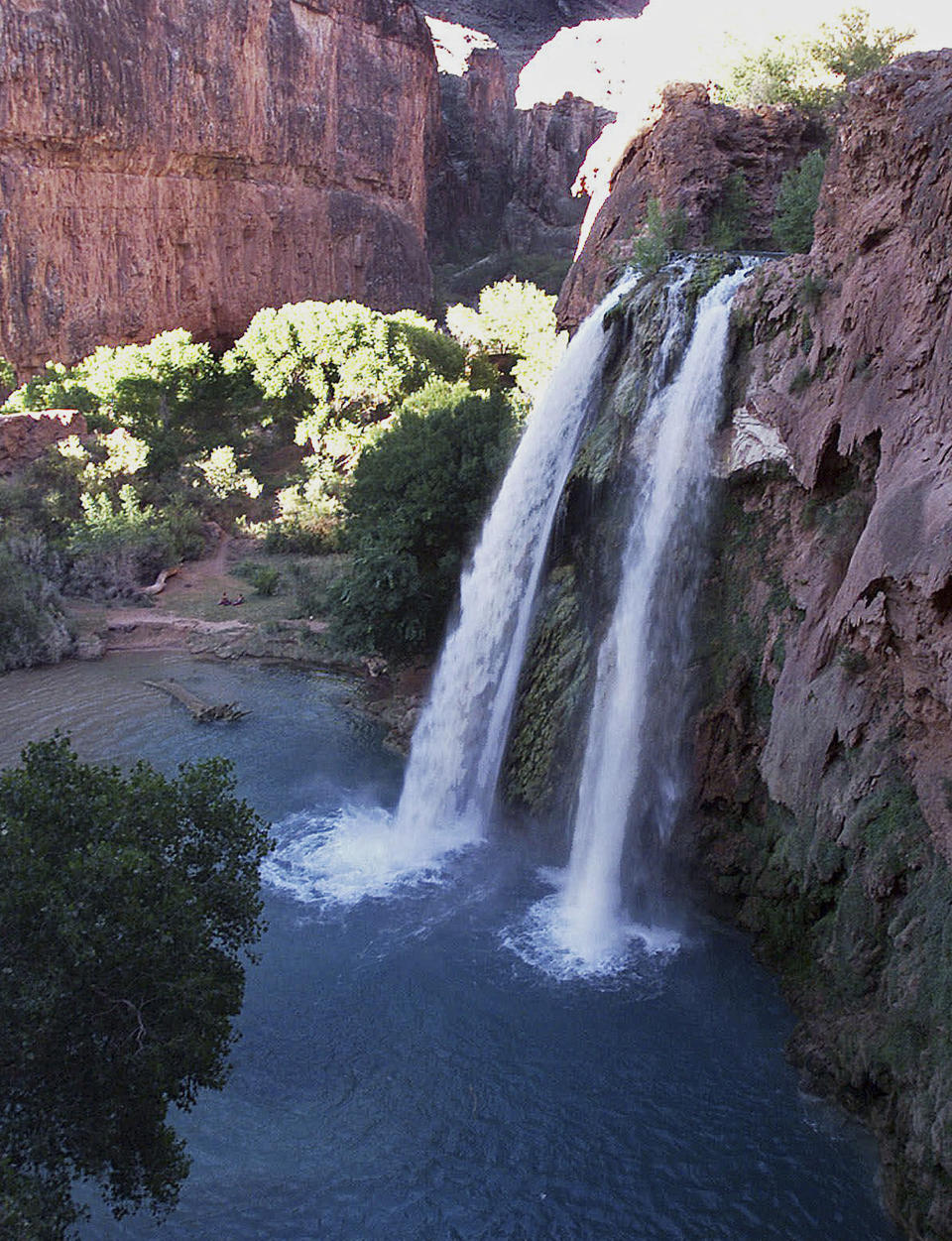 FILE - This 1997 file photo shows one of five waterfalls on Havasu Creek as its waters tumble 210 feet on the Havasupai Tribe's reservation in a southeastern branch of the Grand Canyon near Supai, Ariz. Reservations open up next month for tourists eager to snag a camping spot at the bottom of the Grand Canyon where blue-green waterfalls appear like oases in the desert. (AP Photo/Bob Daugherty, File)