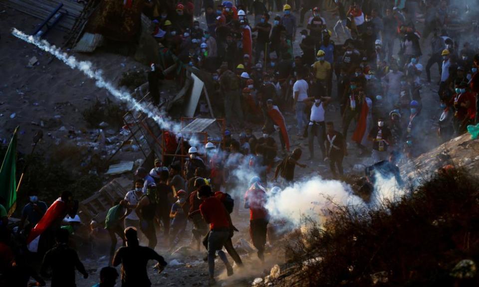 A teargas canister is fired into a group of protesters in Baghdad