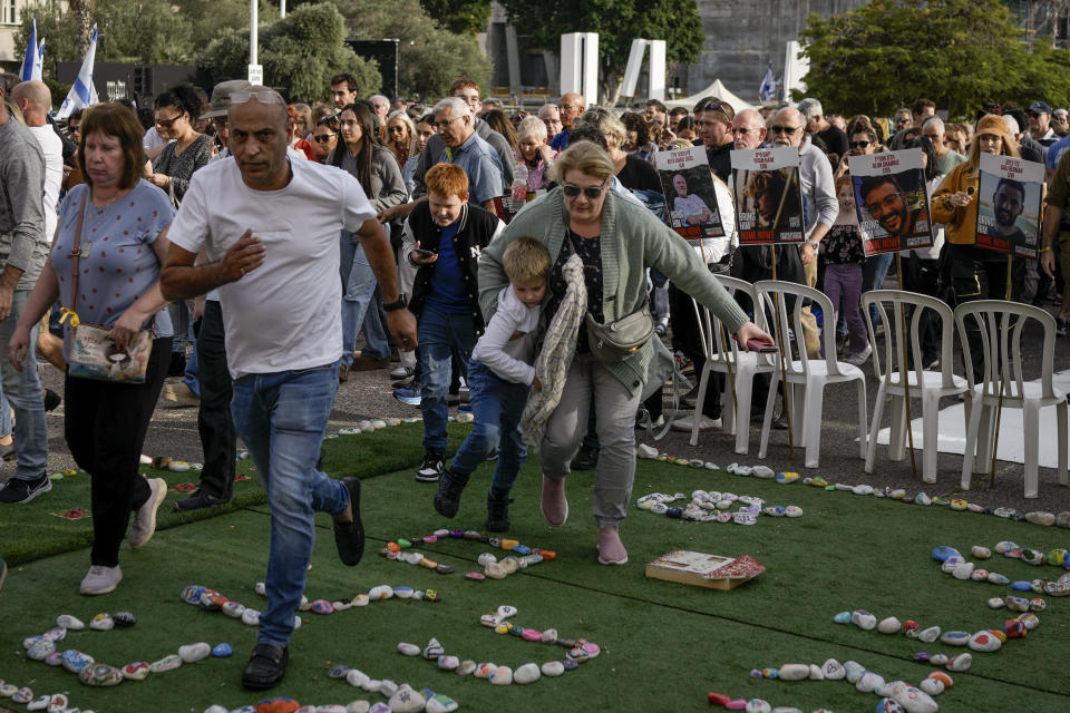 Israelis rush to a shelter as a siren sounds a warning of incoming rockets fired from the Gaza strip, in Tel Aviv, Israel, on Friday, Dec. 8, 2023. (AP Photo/Leo Correa)