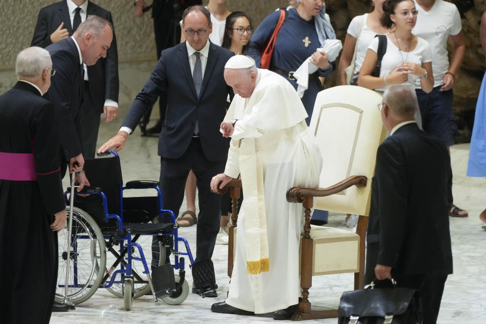 Massimiliano Strappetti, third from left, stands beside Pope Francis during the weekly general audience at the Vatican, Wednesday, Aug. 3, 2022. Francis has promoted the Vatican nurse whom he credited with saving his life to be his "personal health care assistant." The Vatican announced the appointment of Massimiliano Strappetti, currently the nursing coordinator of the Vatican's health department, in a one-line statement Thursday.(AP Photo/Gregorio Borgia)