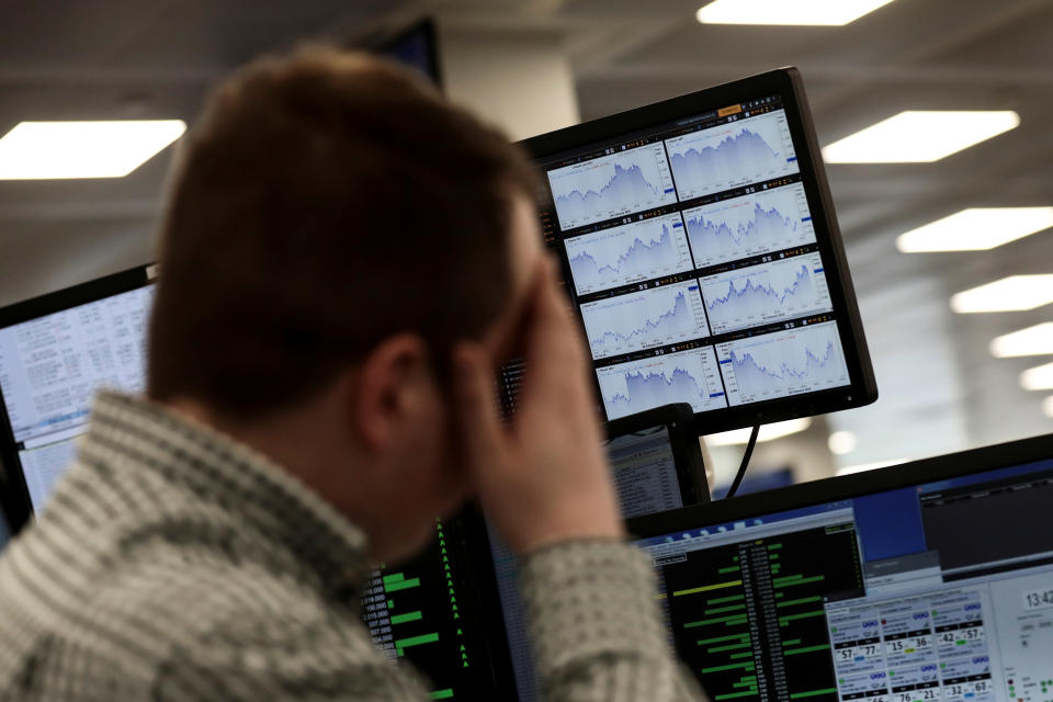 A trader looks at financial information on computer screens on the IG Index the trading floor in London, Britain February 6, 2018. REUTERS/Simon Dawson