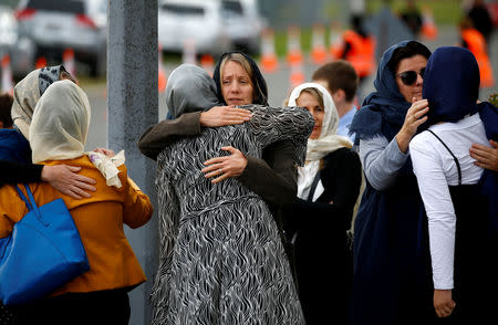 People hug as they attend the burial ceremony of the victims of the mosque attacks, at the Memorial Park Cemetery in Christchurch, New Zealand March 21, 2019. REUTERS/Edgar Su